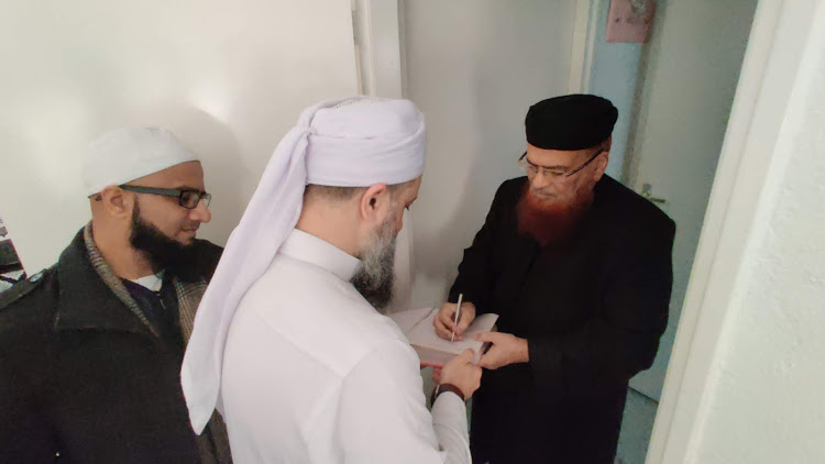 Shaykh Muqaddami having his booked signed